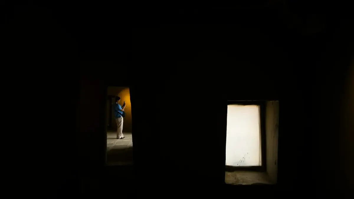 A person stands in a dark room.