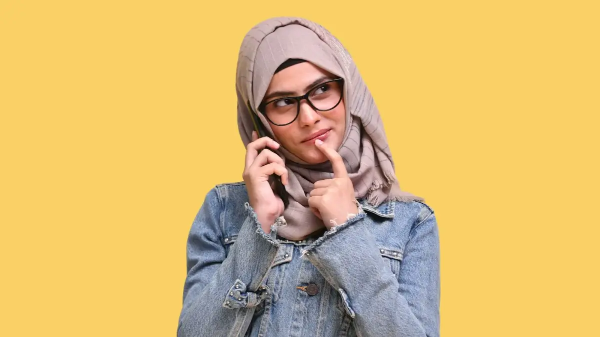 a person wearing a hoodie and holding the hands to the mouth