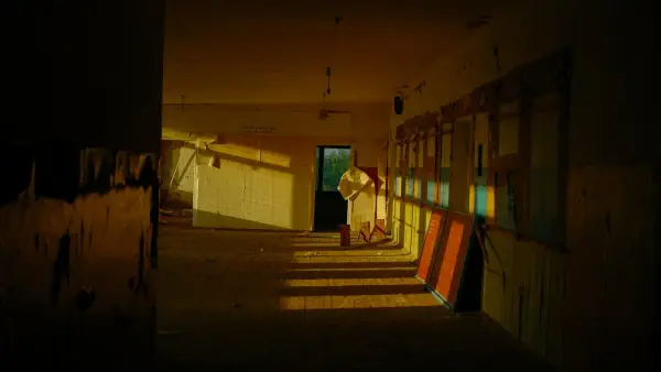 Sunlight streams into an empty hallway with colorful reflections.