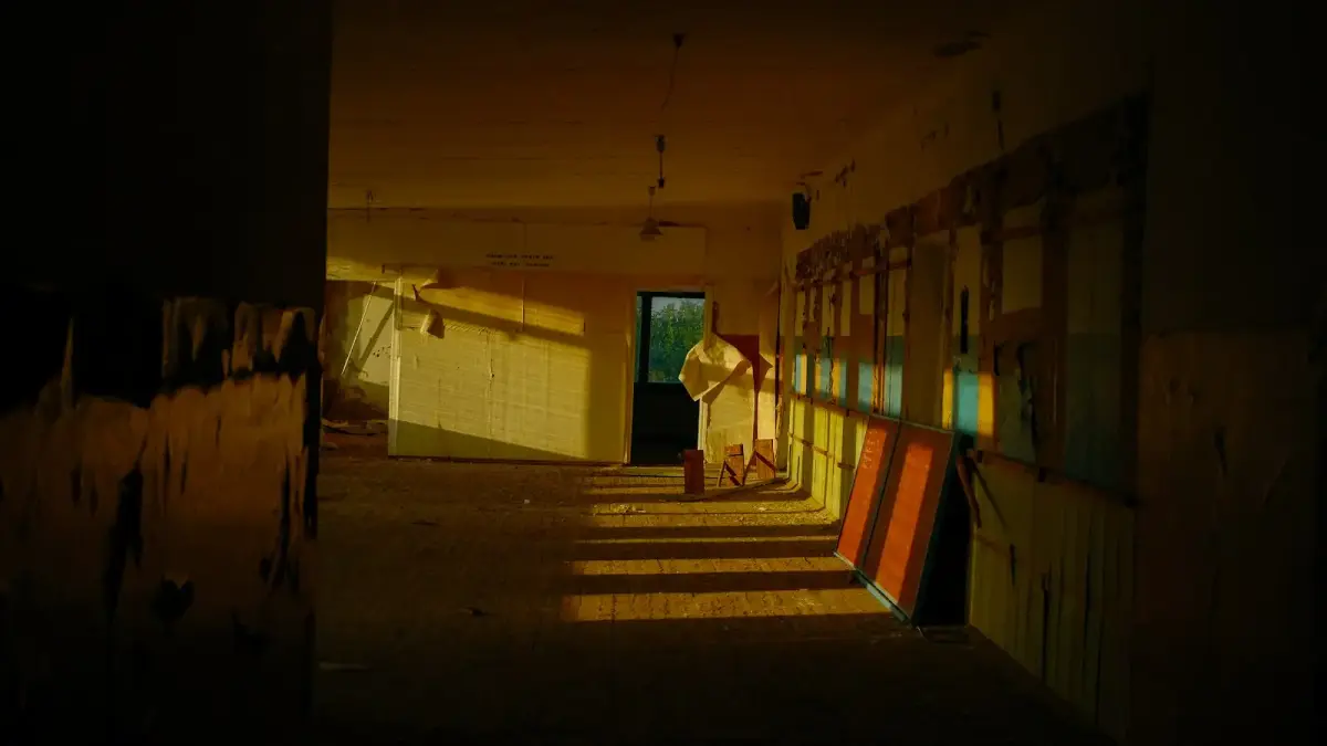 Sunlight streams into an empty hallway with colorful reflections.