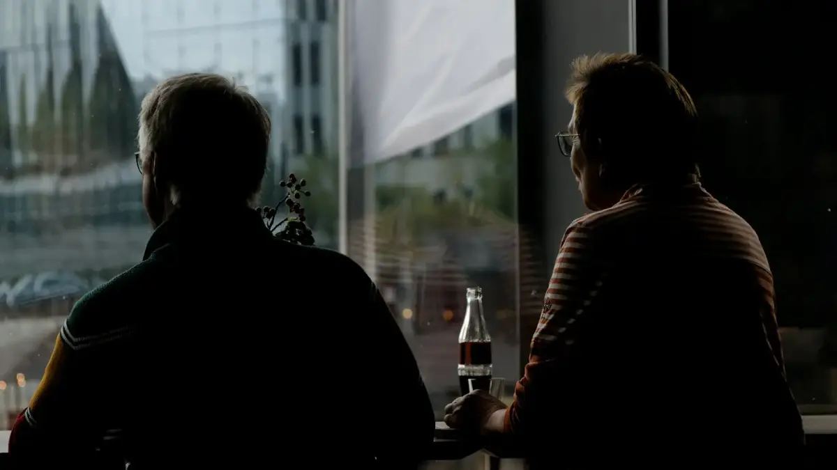 a couple of people sitting at a table next to a window