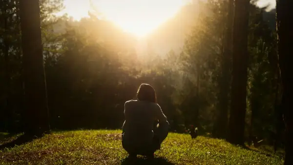 A quiet child sitting alone on stairs in soft morning light