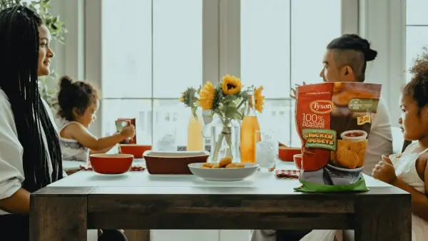 woman in black tank top sitting on chair in front of table with orange ceramic bowl