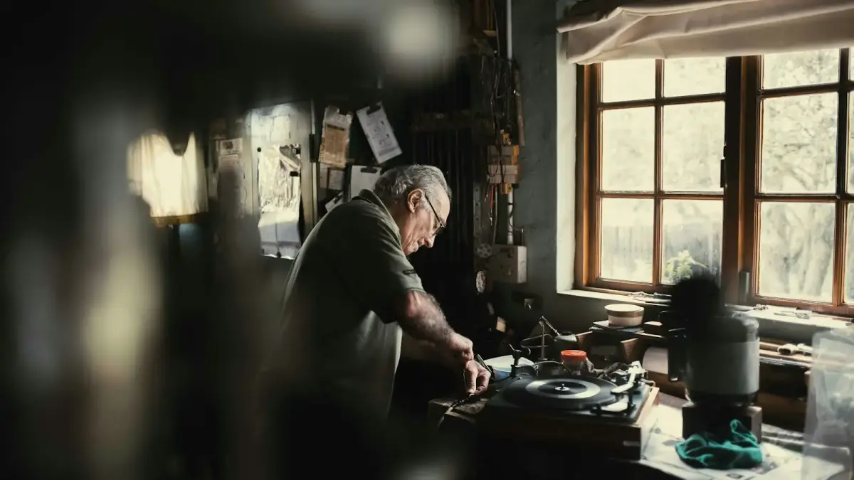 man holding handheld tool standing beside window