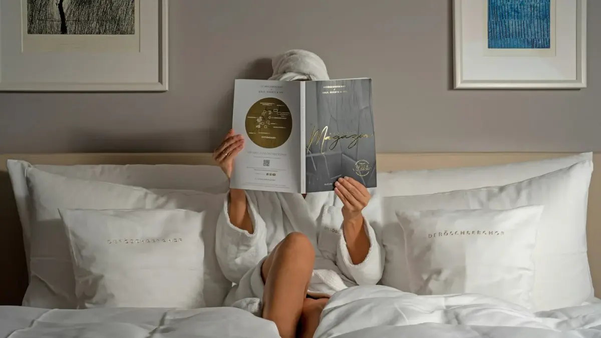 a person reading a book on a bed