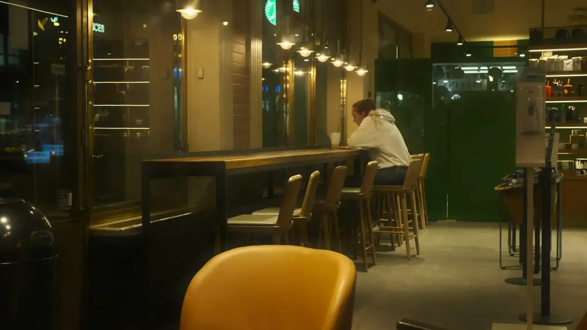 Person sitting alone at a cafe counter