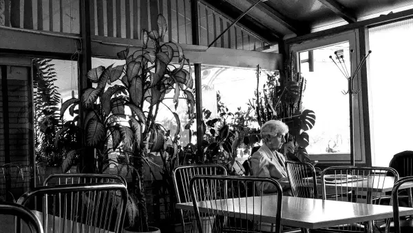 Elderly woman sitting at a table in a cafe