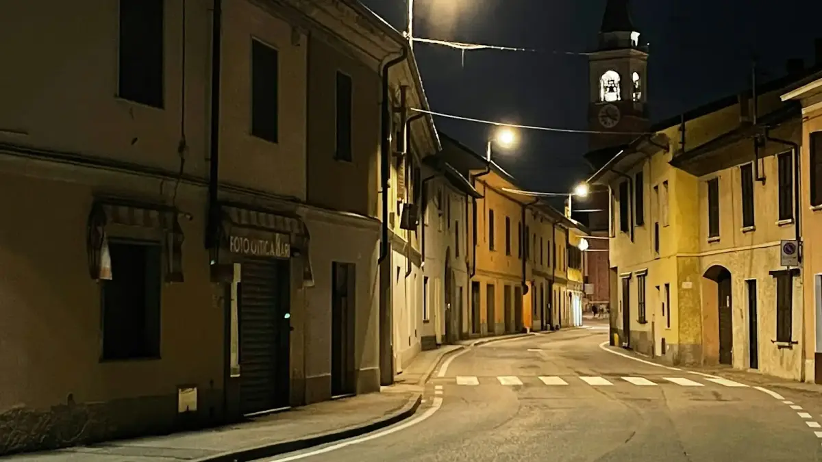 Empty street with buildings and clock tower at night