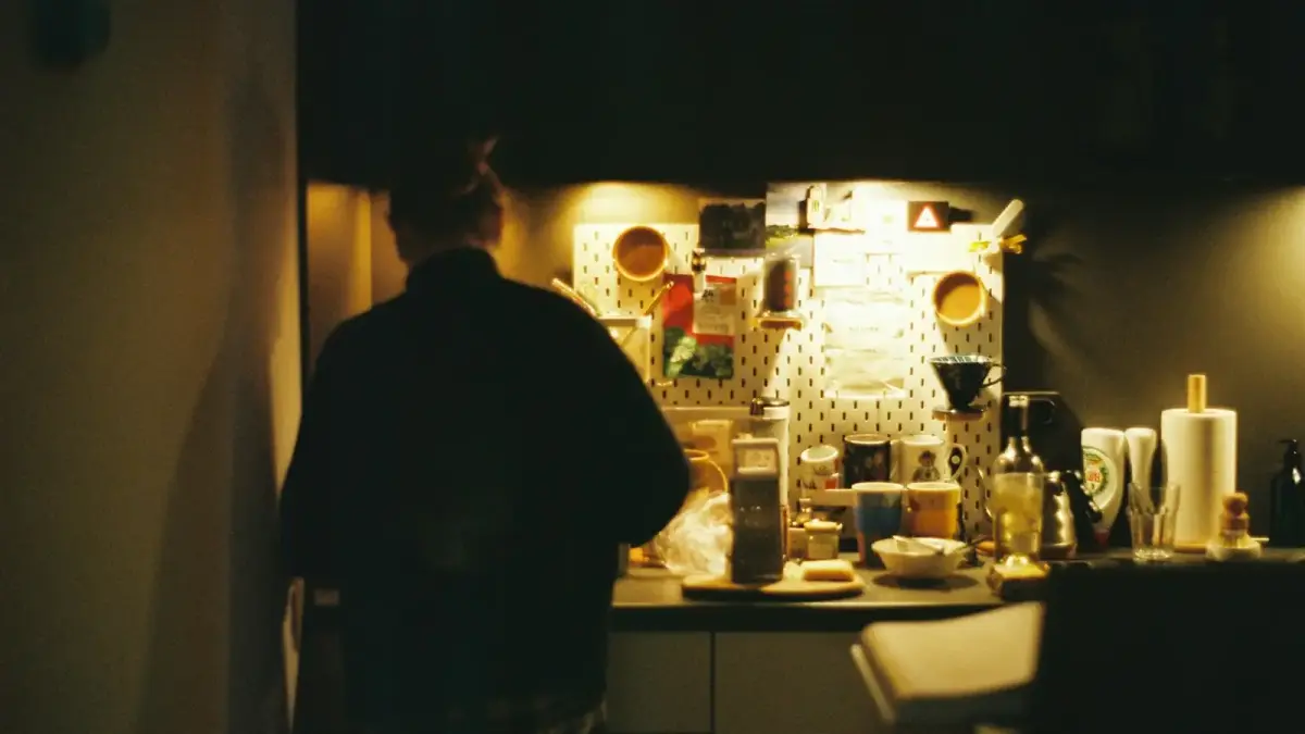 a man standing in a kitchen next to a refrigerator