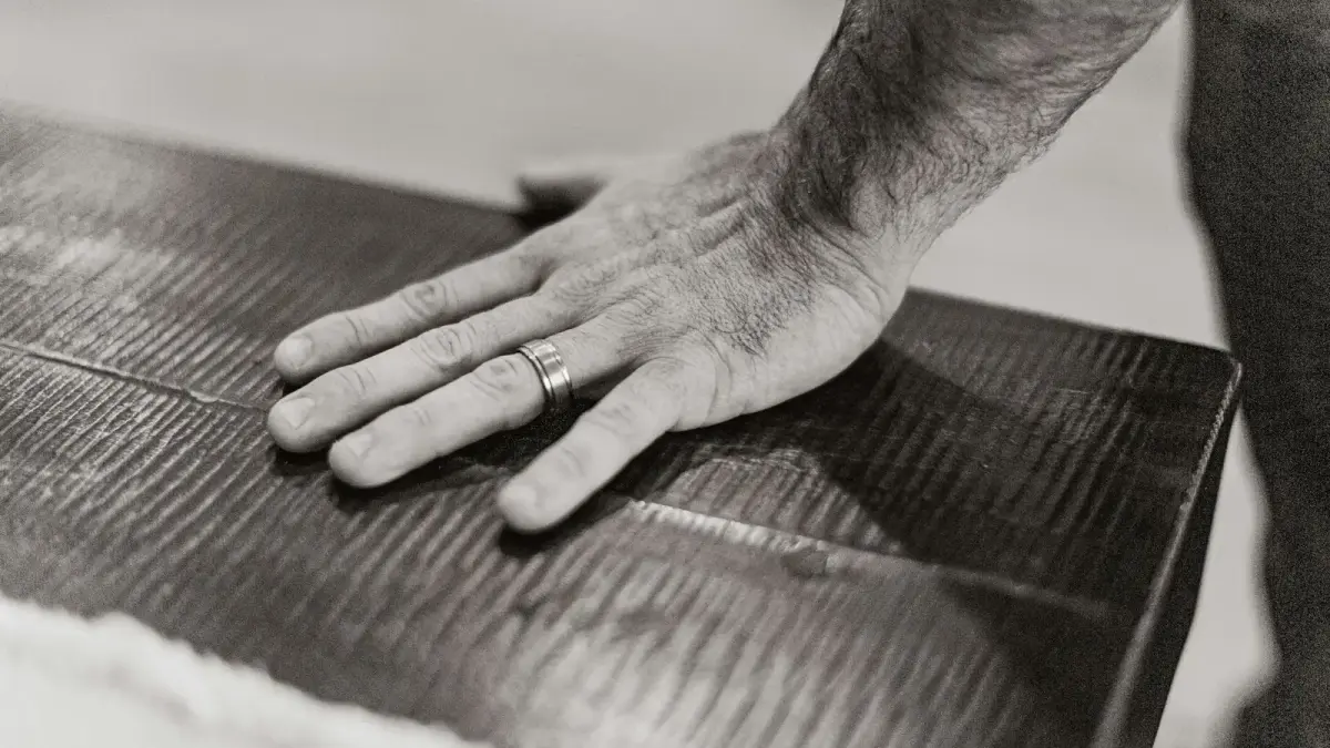A man with his hand on a piece of luggage