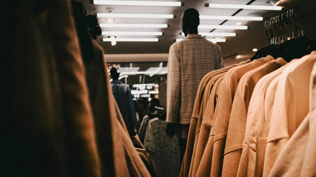 man in gray suit jacket standing in front of brown leather chairs