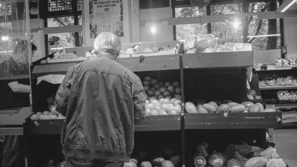 a man standing in front of a display of vegetables