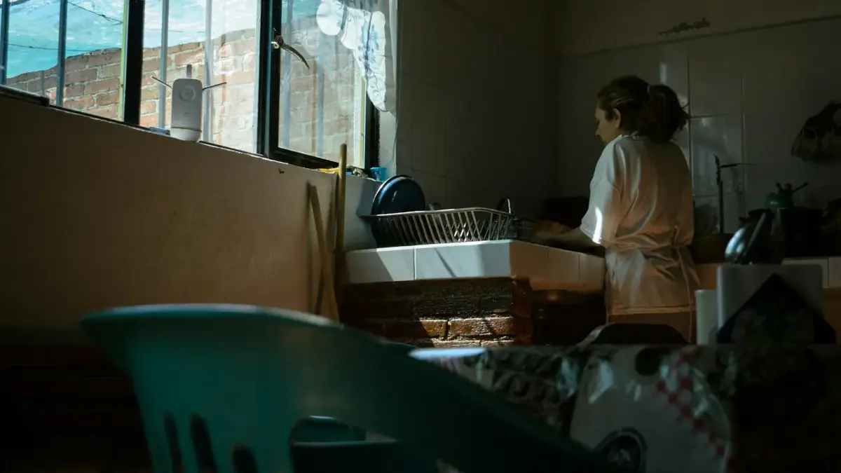 A woman standing in front of a window in a room