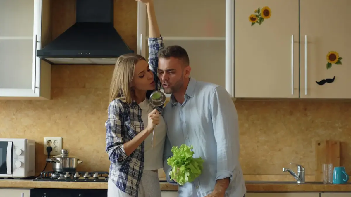 Couple dancing and singing in a kitchen