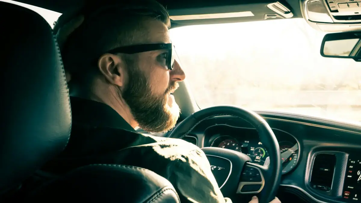 man in black jacket driving car