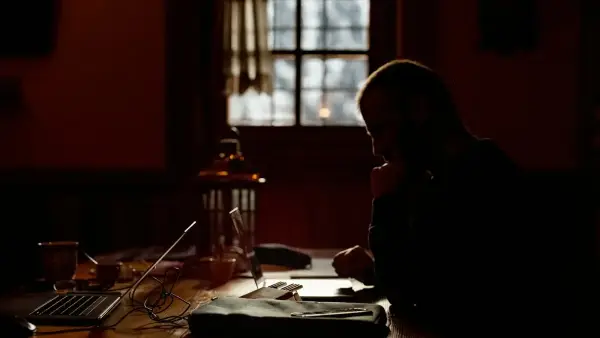 a person sitting at a table in a dark room
