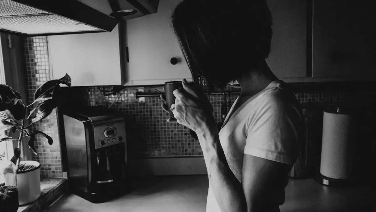 man in white t-shirt holding black smartphone