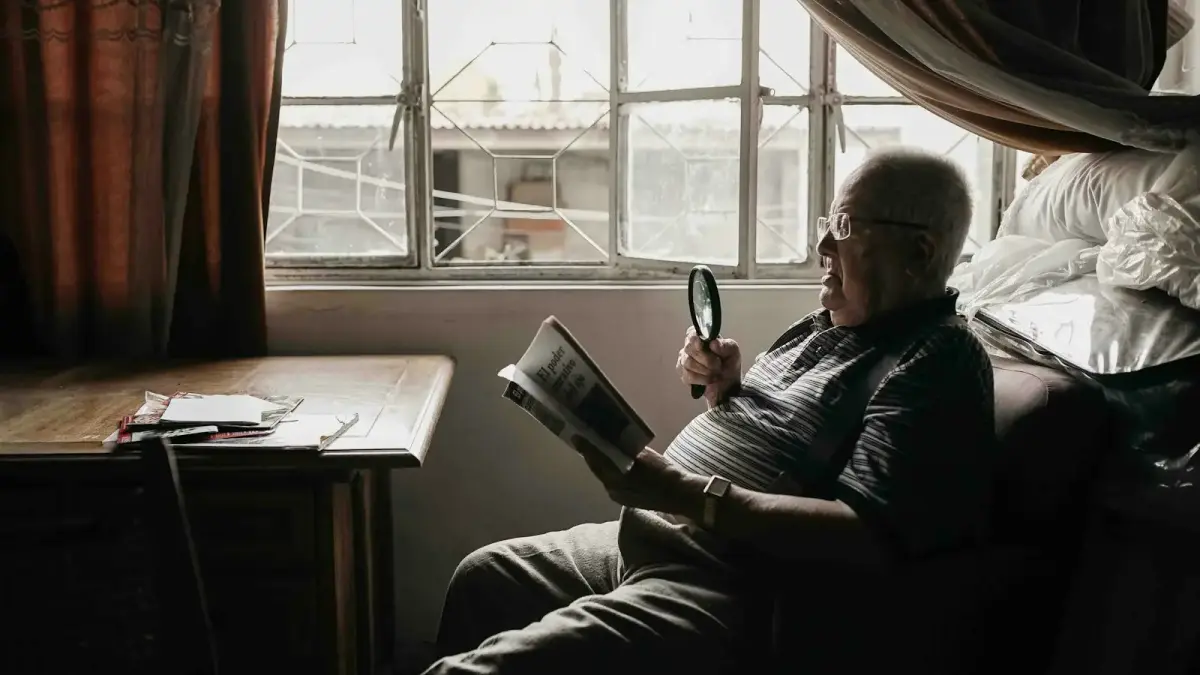 a man sitting in a chair holding a magnifying glass