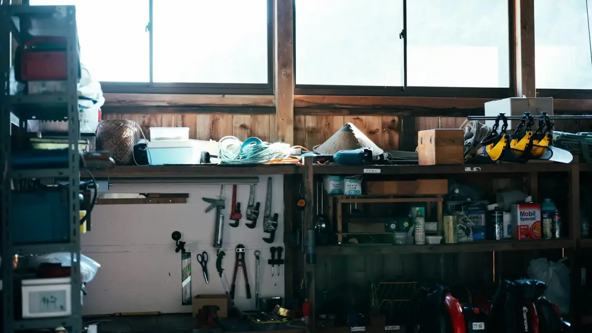 A cluttered workshop shelf with tools and supplies