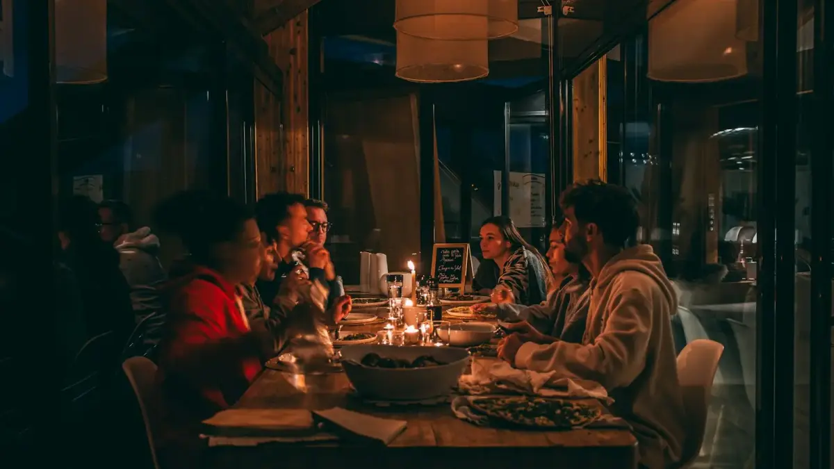 People enjoying a candlelit dinner at a dimly lit restaurant.