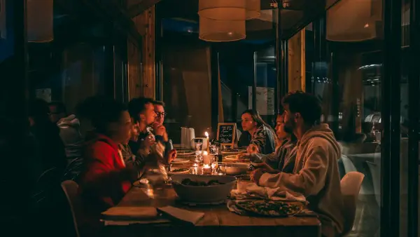 People enjoying a candlelit dinner at a dimly lit restaurant.