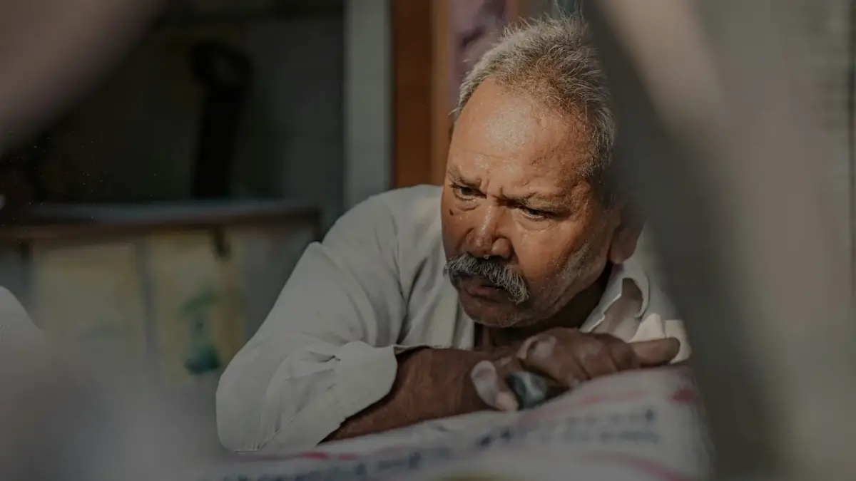 a man looking at a newspaper with a concerned look on his face