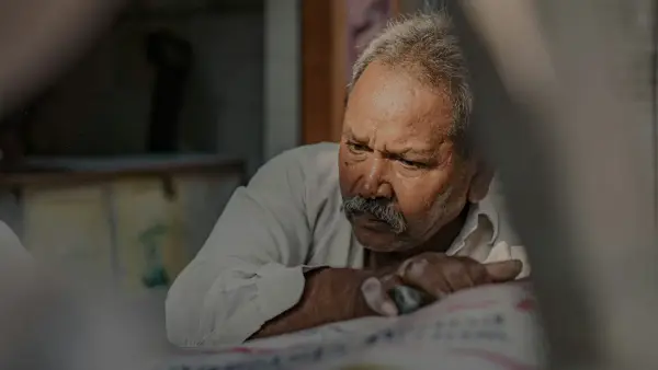 a man looking at a newspaper with a concerned look on his face