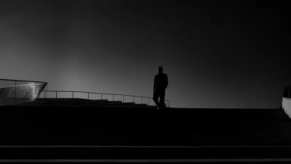 A man standing on top of a roof next to a building