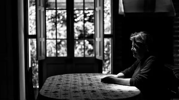 a black and white photo of a woman sitting at a table