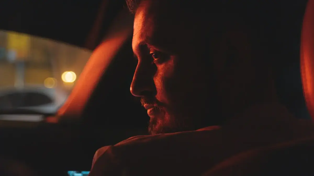 a man sitting in a car at night