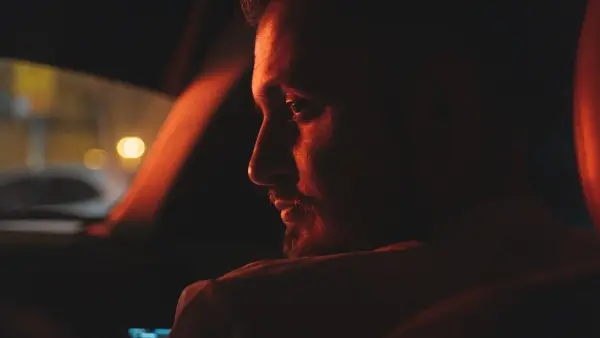 a man sitting in a car at night