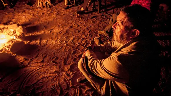 a man sitting in front of a campfire