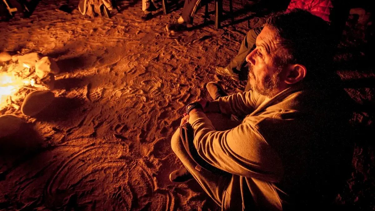 a man sitting in front of a campfire