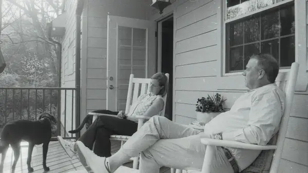 A couple and their dog relaxing on a porch
