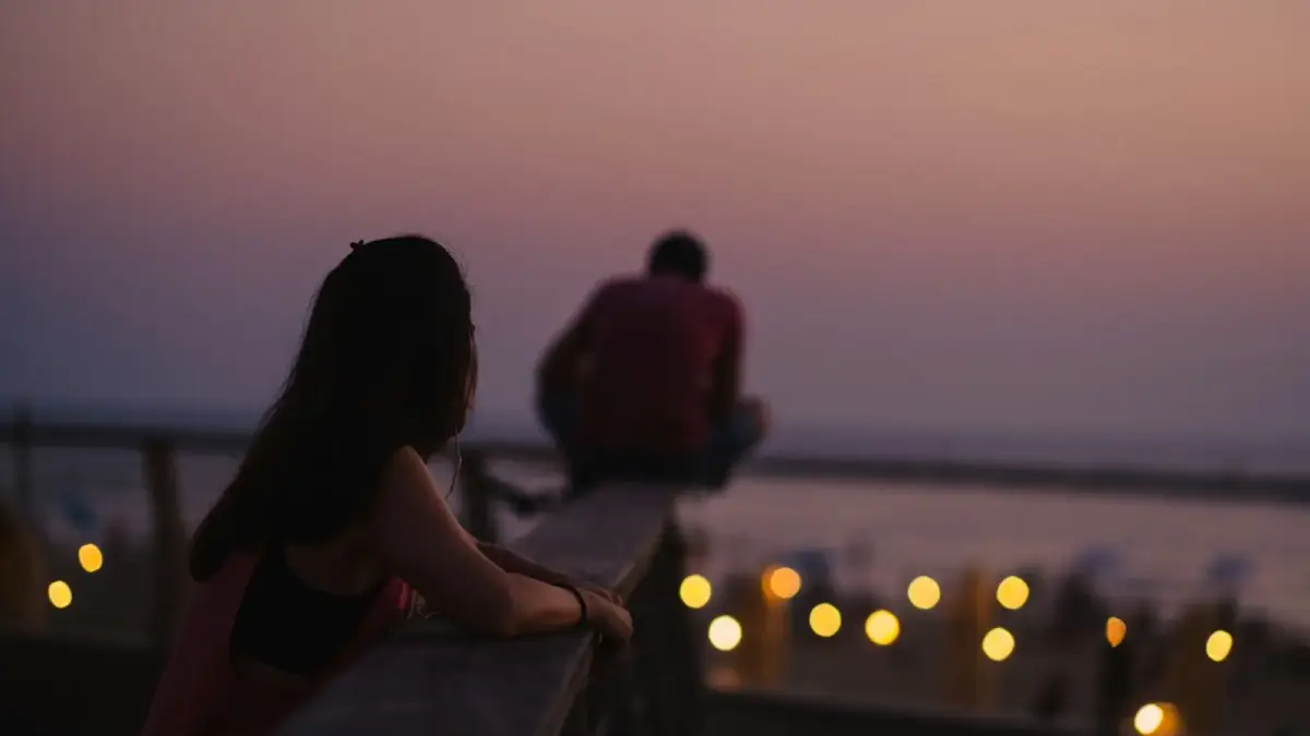An older couple sitting together at a kitchen table in morning light