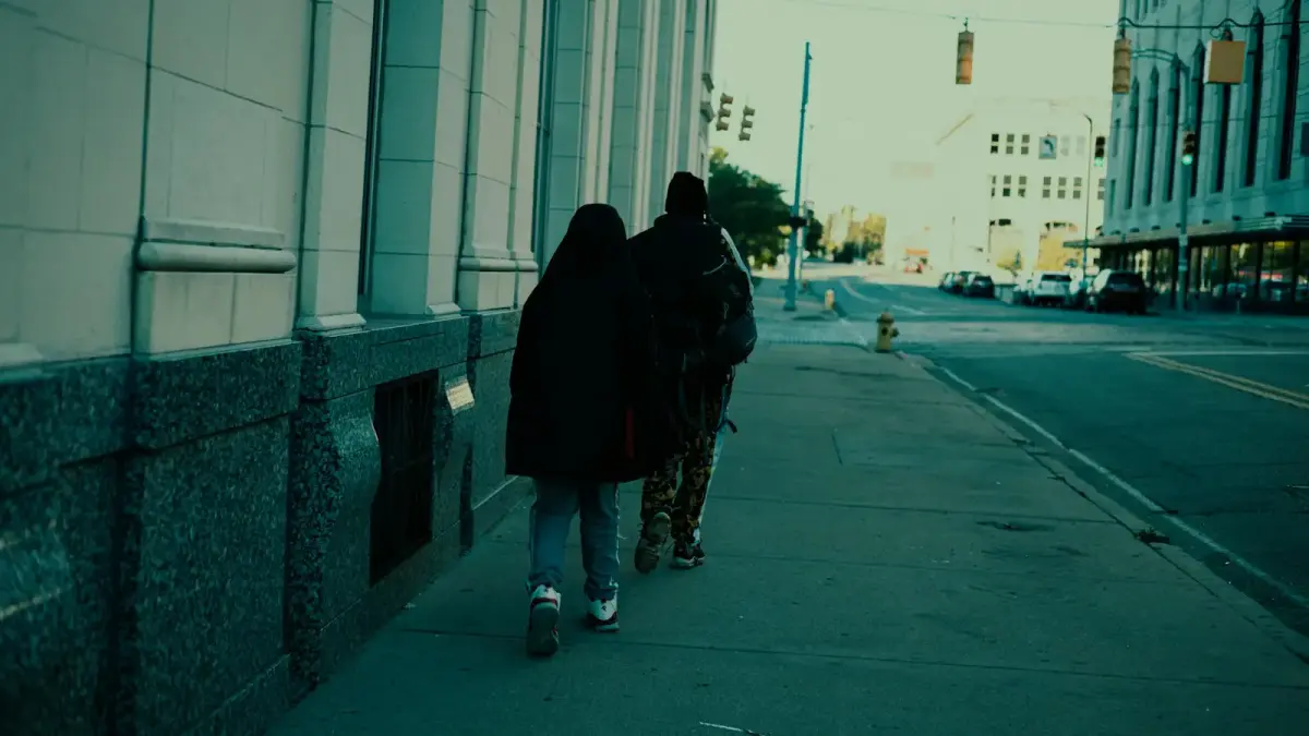 a couple of people walking down a sidewalk