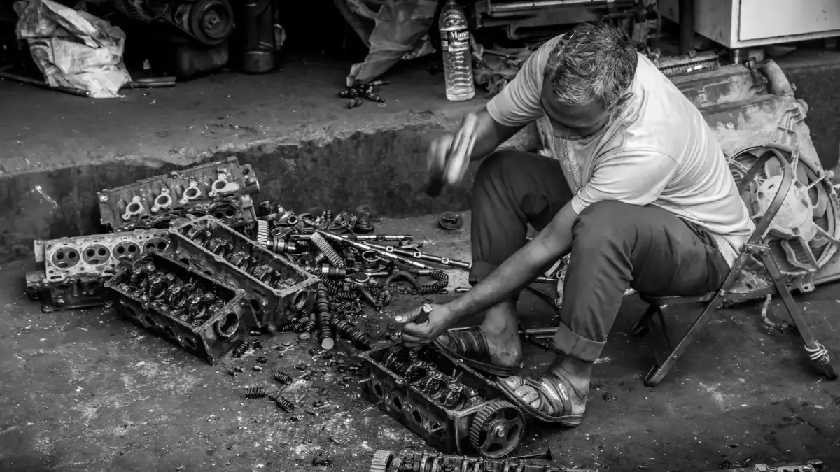 Mechanic working on car engine parts