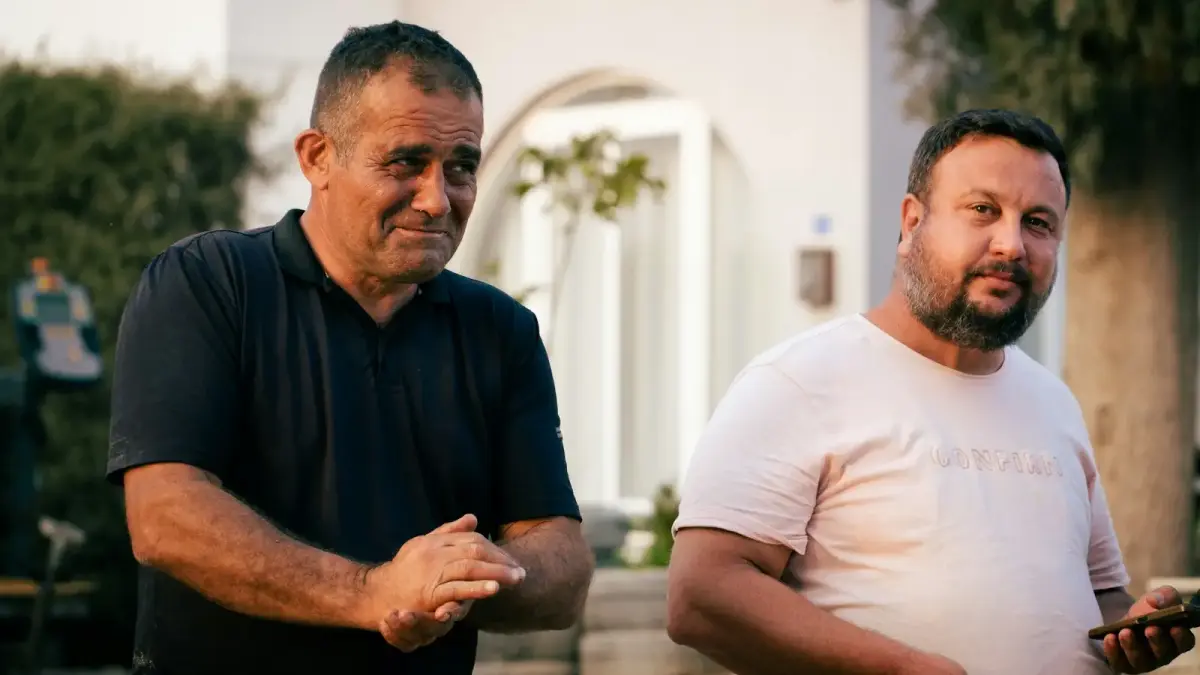Two men standing outdoors near a building.