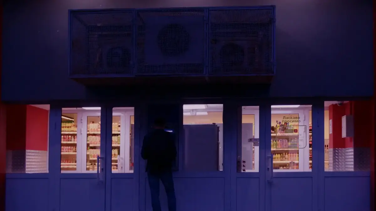 a man standing in front of a store at night
