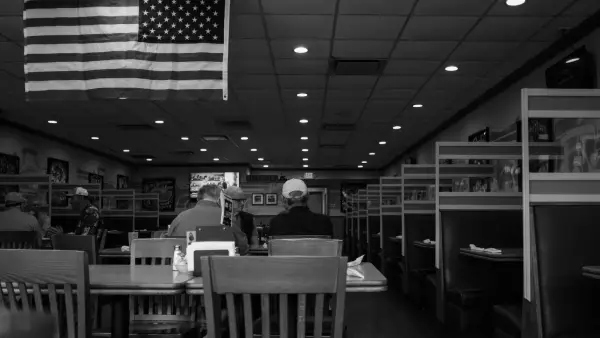 American flag hangs above diners in a restaurant.