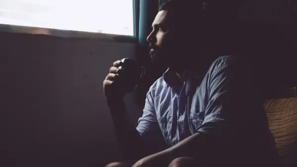 man sitting on chair holding mug