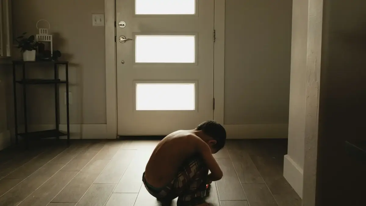 A person kneeling on the floor in front of a door