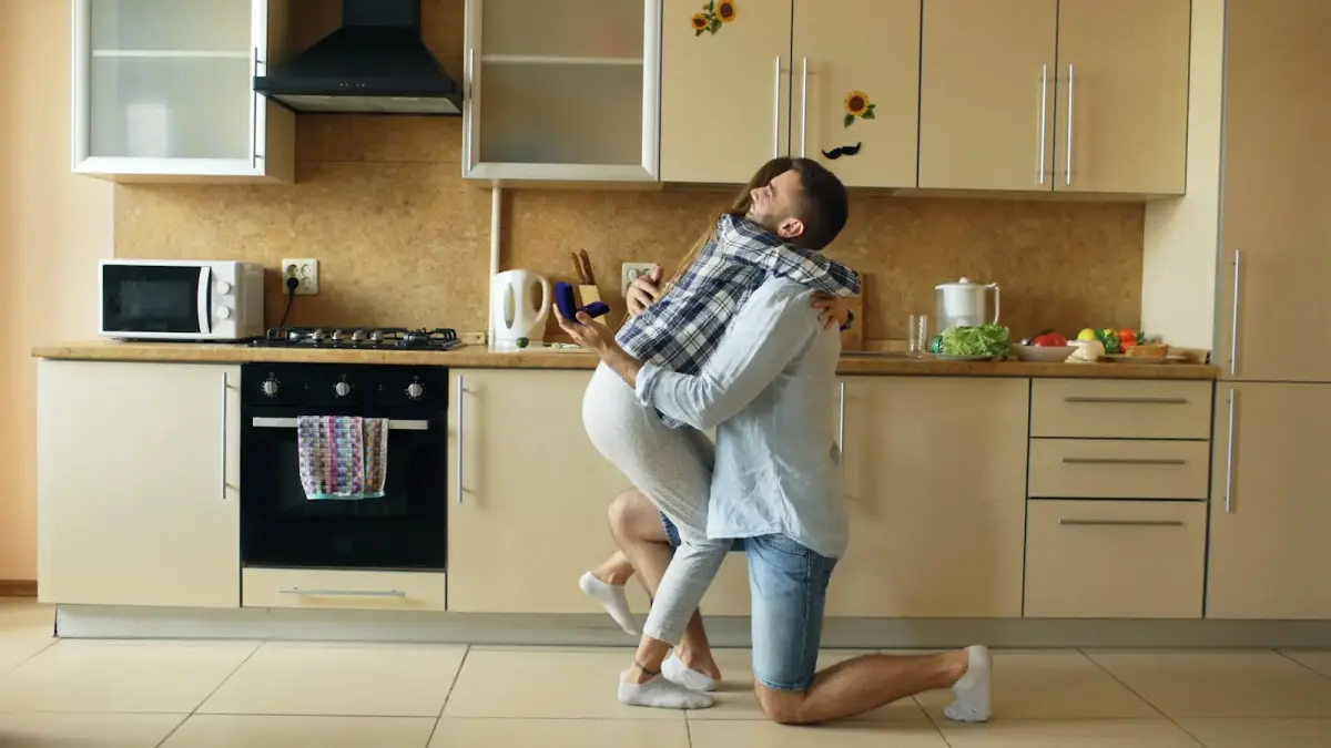 Couple embracing in a modern kitchen.