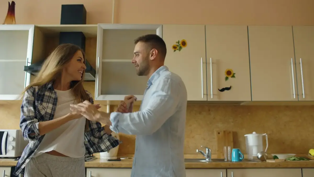 Couple dancing happily in a kitchen