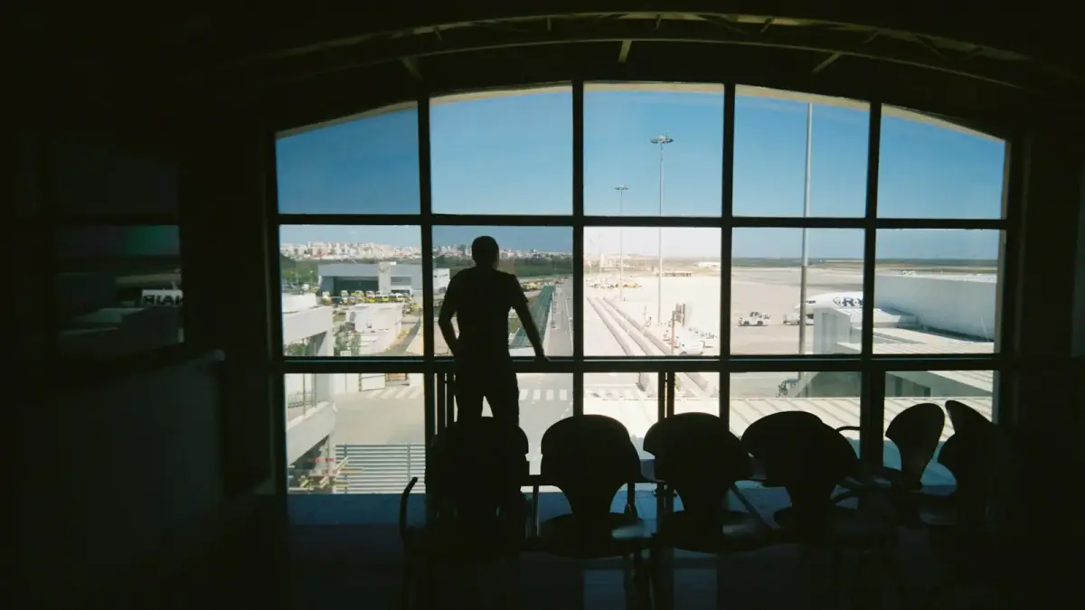 silhouette of man standing near glass window