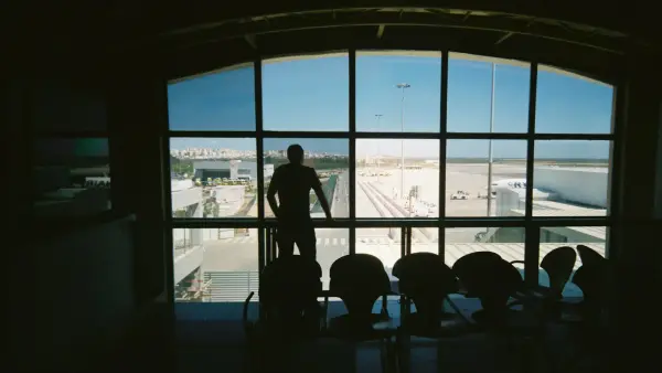 silhouette of man standing near glass window