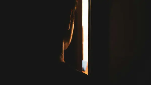 person looking throughh crack on door