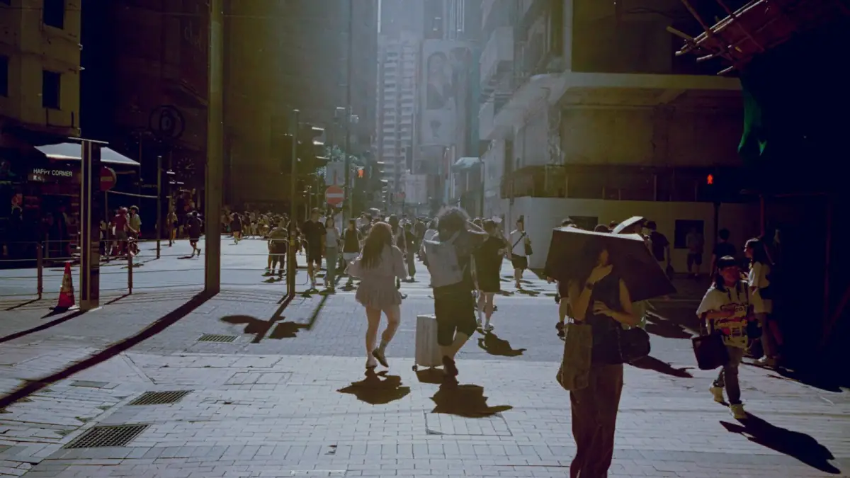 People walking down a sunlit city street.