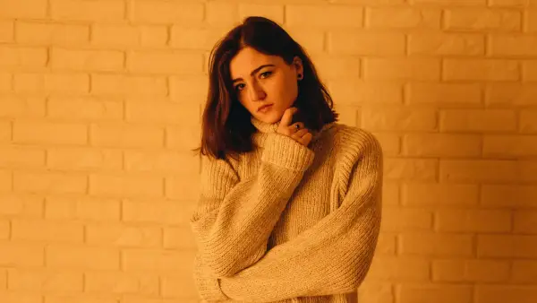 Person with arms crossed in contemplative posture