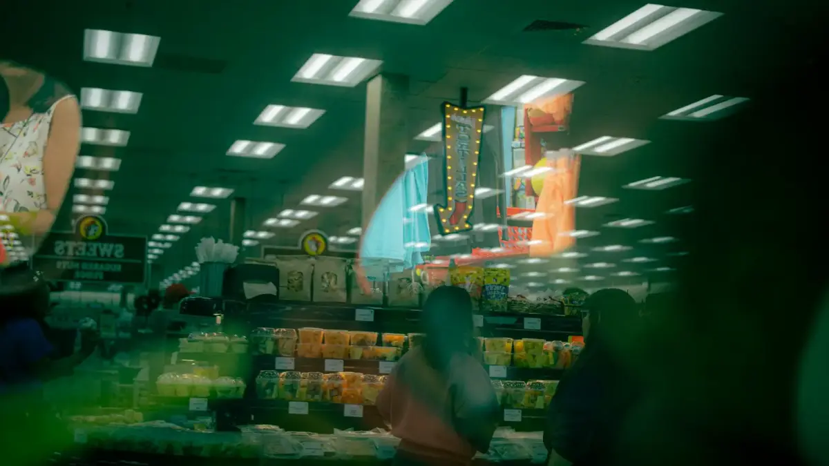 Blurry supermarket interior with bright lights and shelves.